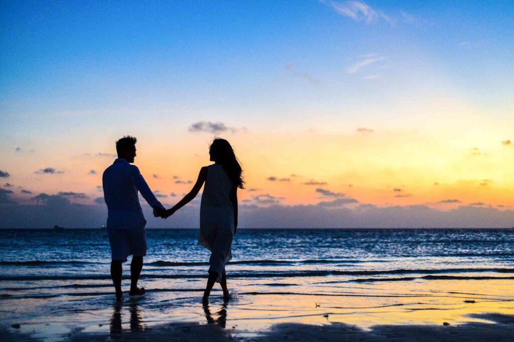 Paar Hand in Hand Strand Sonnenuntergang Romantische Reise Die schönsten Ausflugsziele weltweit